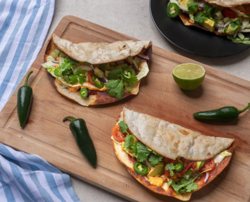 Smashed tacos siskonmakkarasta, täytteenä salaattia, tomaattia, avokadoa, jalapenoa ja tuoretta korianteria.